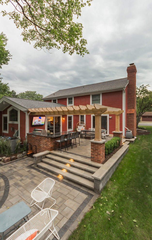 Modelo de patio de estilo americano pequeño en patio trasero con cocina exterior, adoquines de ladrillo y pérgola