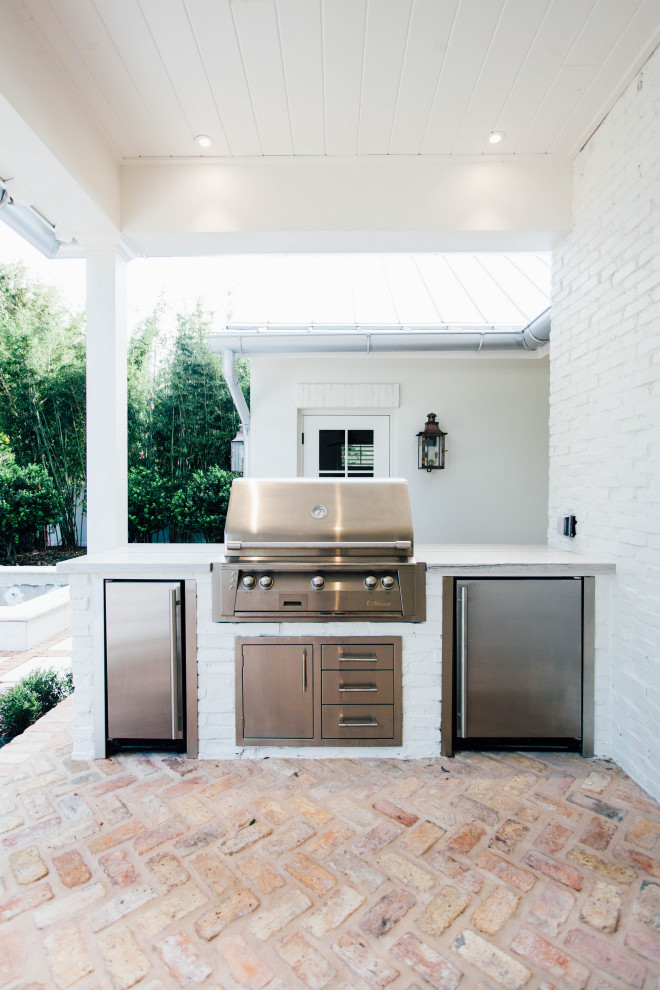 Inspiration for a mid-sized transitional backyard brick patio kitchen remodel in Orlando with a roof extension