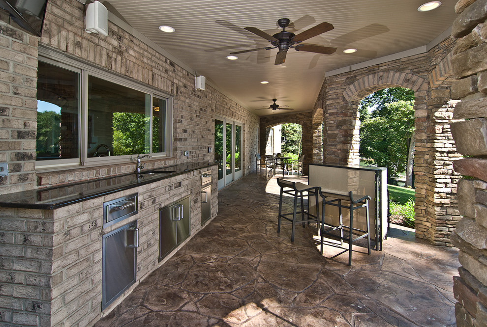 Example of a mid-sized trendy backyard stamped concrete patio kitchen design in Charlotte with a roof extension