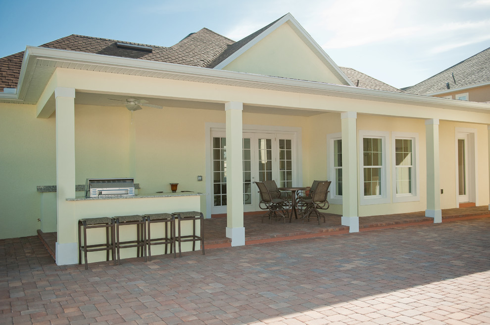 Cette image montre une terrasse arrière rustique de taille moyenne avec une cuisine d'été, des pavés en brique et une extension de toiture.