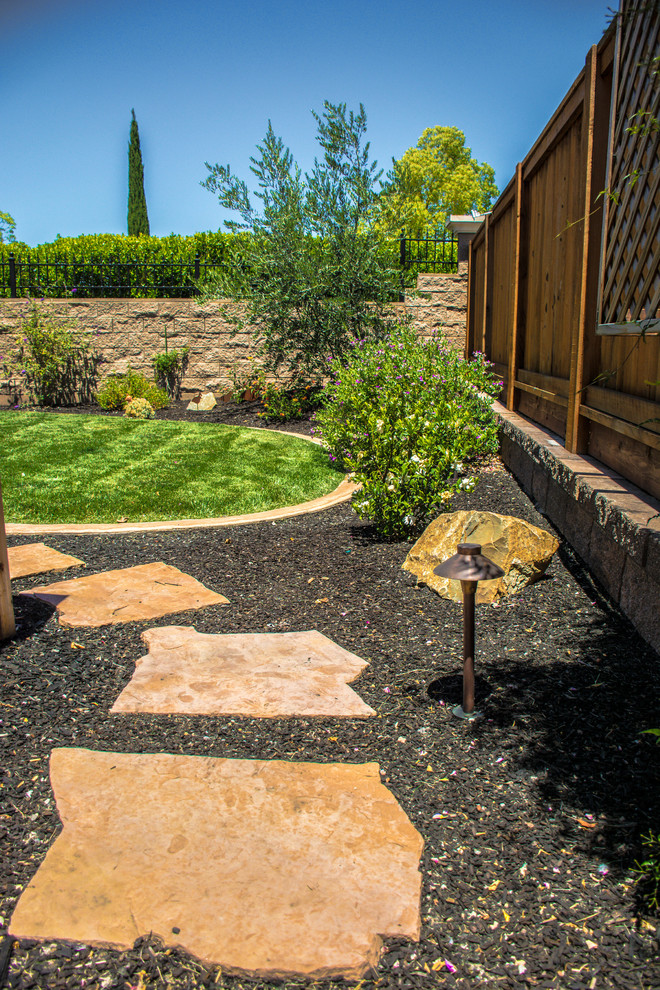 Diseño de jardín tradicional renovado de tamaño medio en patio trasero con adoquines de piedra natural