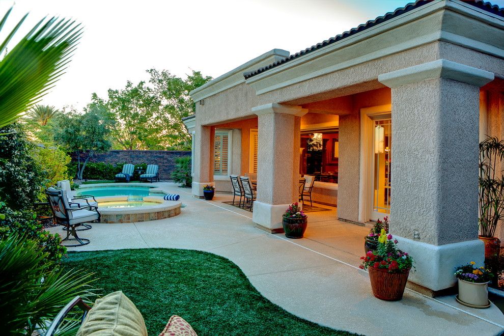 Esempio di un patio o portico classico dietro casa e di medie dimensioni con pedane e un tetto a sbalzo