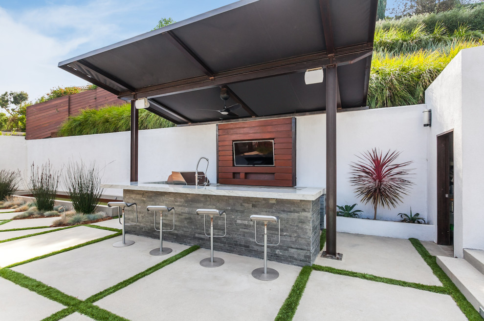 Ispirazione per un grande patio o portico minimalista dietro casa con pavimentazioni in cemento e un parasole