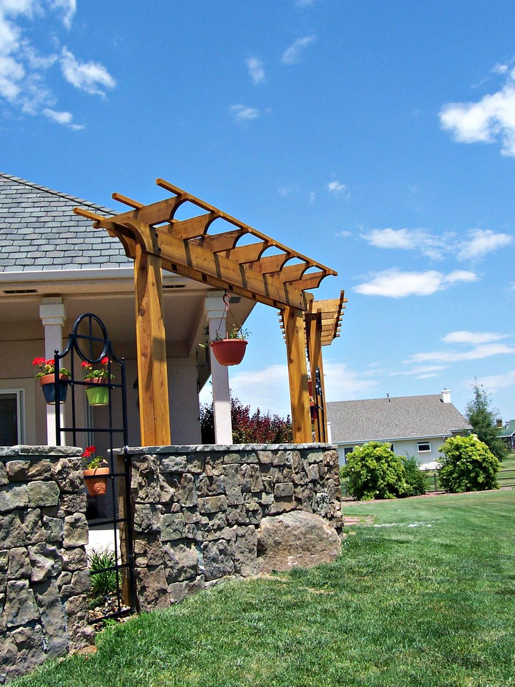 Inspiration for a large timeless backyard stone patio remodel in Denver with a pergola