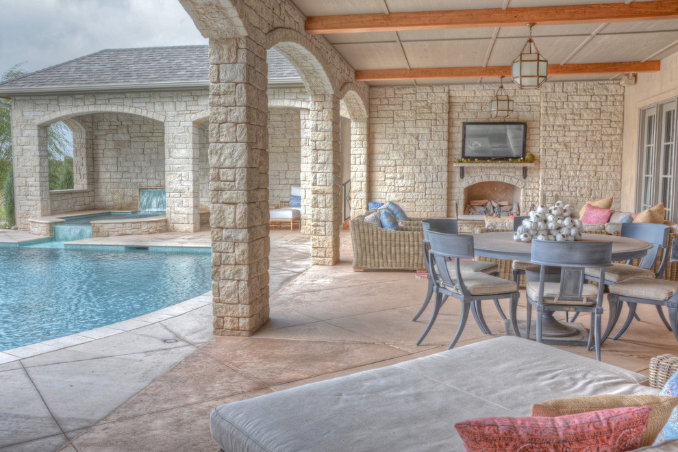 Inspiration for a huge mediterranean backyard stamped concrete patio remodel in Oklahoma City with a roof extension
