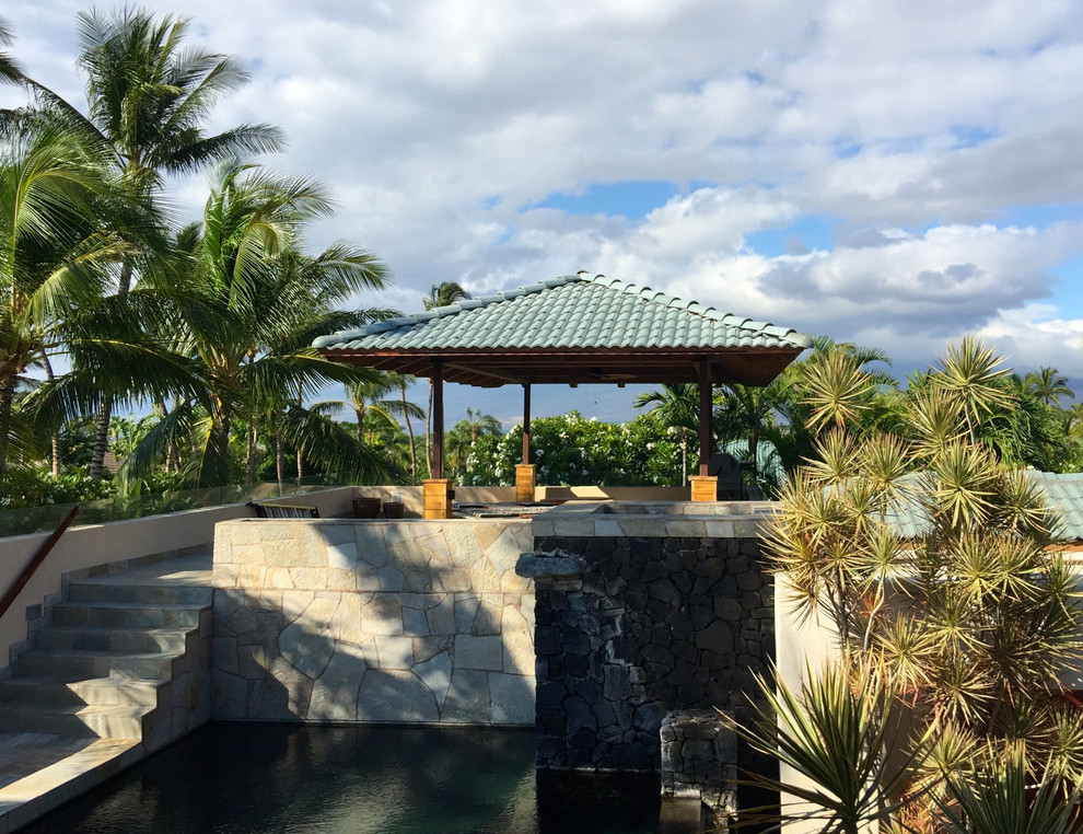 ハワイにあるラグジュアリーな広いトロピカルスタイルのおしゃれな裏庭のテラス (噴水、天然石敷き、ガゼボ・カバナ) の写真