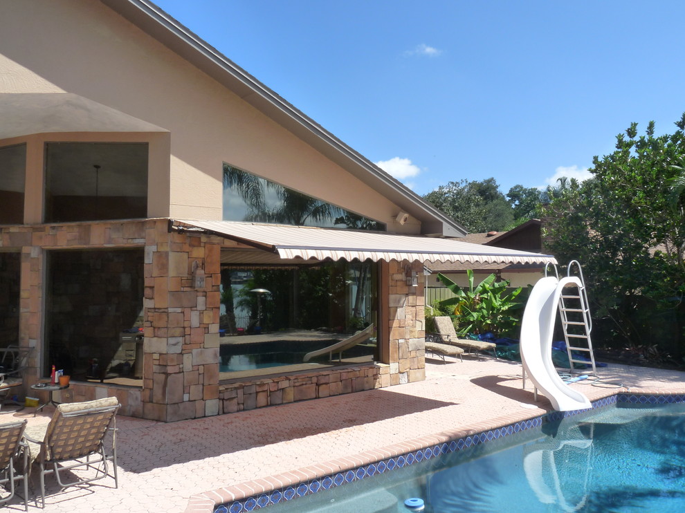 Inspiration for a tropical backyard patio remodel in Orlando with an awning