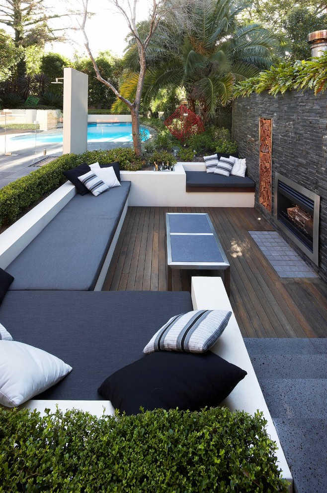 Inspiration pour une terrasse arrière design avec un foyer extérieur.