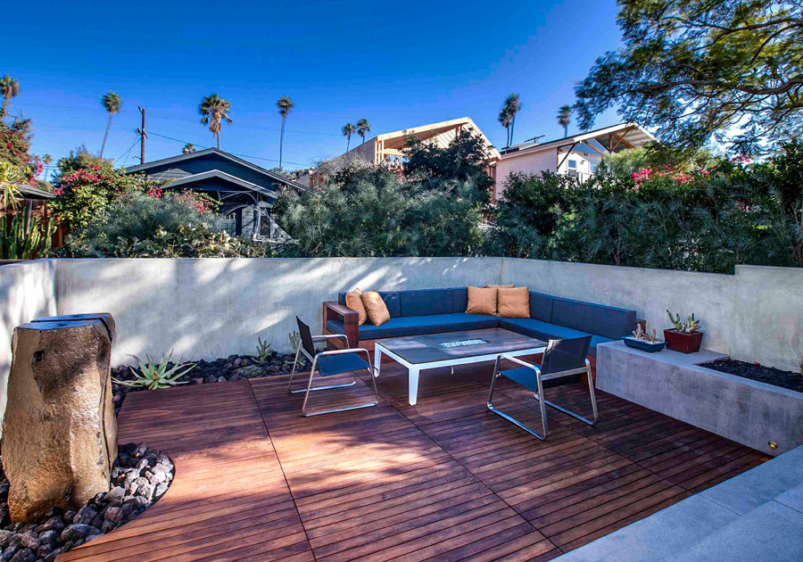 Example of a large trendy front yard patio design in Los Angeles with a fire pit, decking and no cover