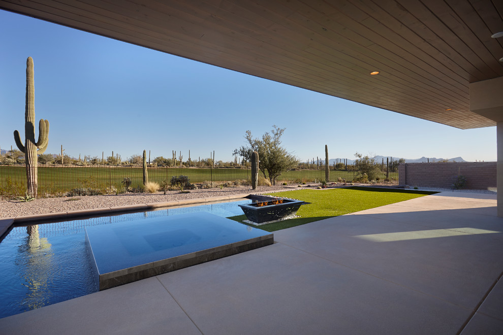 フェニックスにある高級な中くらいなコンテンポラリースタイルのおしゃれな裏庭のテラス (ファイヤーピット、コンクリート板舗装	、張り出し屋根) の写真
