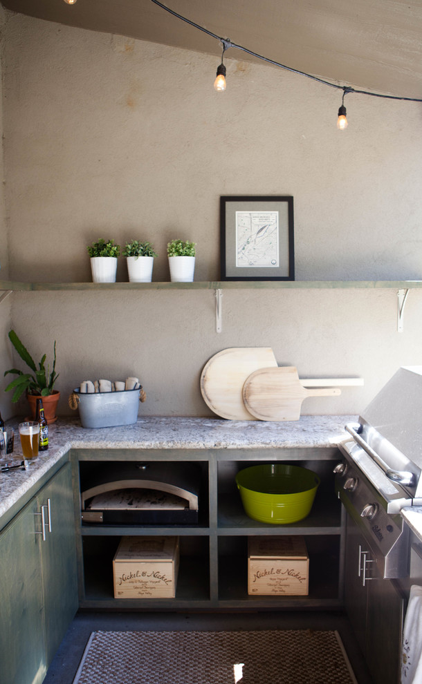 Cette photo montre une terrasse arrière tendance de taille moyenne avec une cuisine d'été, une dalle de béton et une extension de toiture.