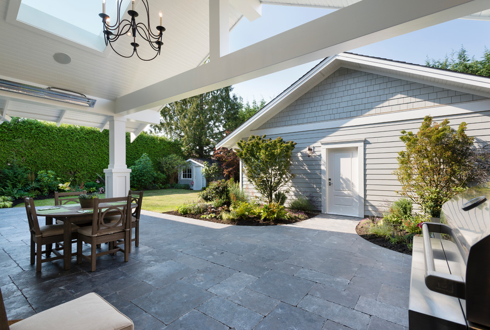 Foto di un grande patio o portico classico dietro casa con pavimentazioni in cemento e un tetto a sbalzo