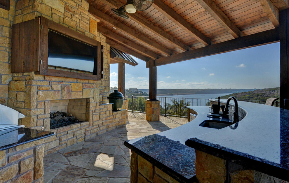 Example of a mountain style backyard concrete patio kitchen design in Dallas with a roof extension