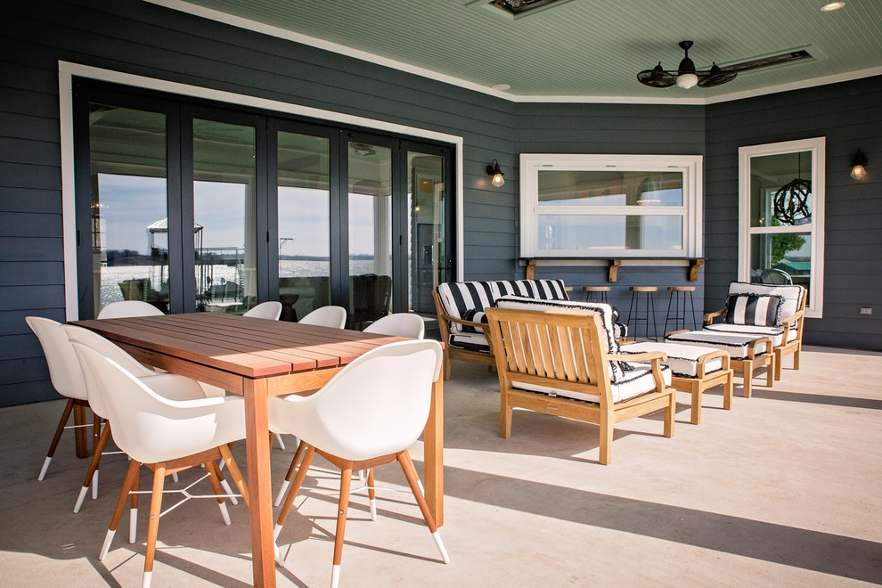 Large beach style backyard concrete patio photo in Dallas with a roof extension