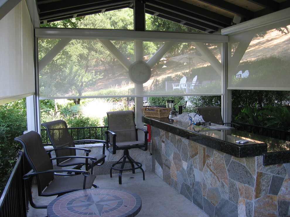 Réalisation d'une grande terrasse arrière tradition avec une cuisine d'été, une pergola et une dalle de béton.