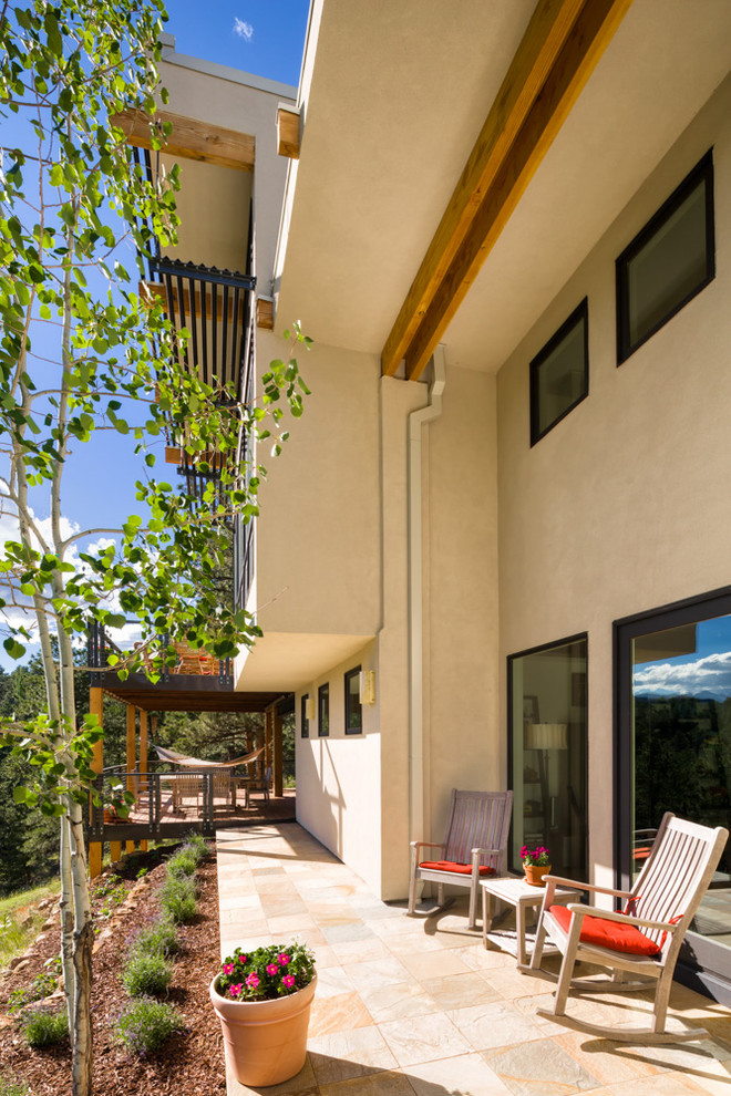 Immagine di un piccolo patio o portico moderno davanti casa con nessuna copertura e piastrelle