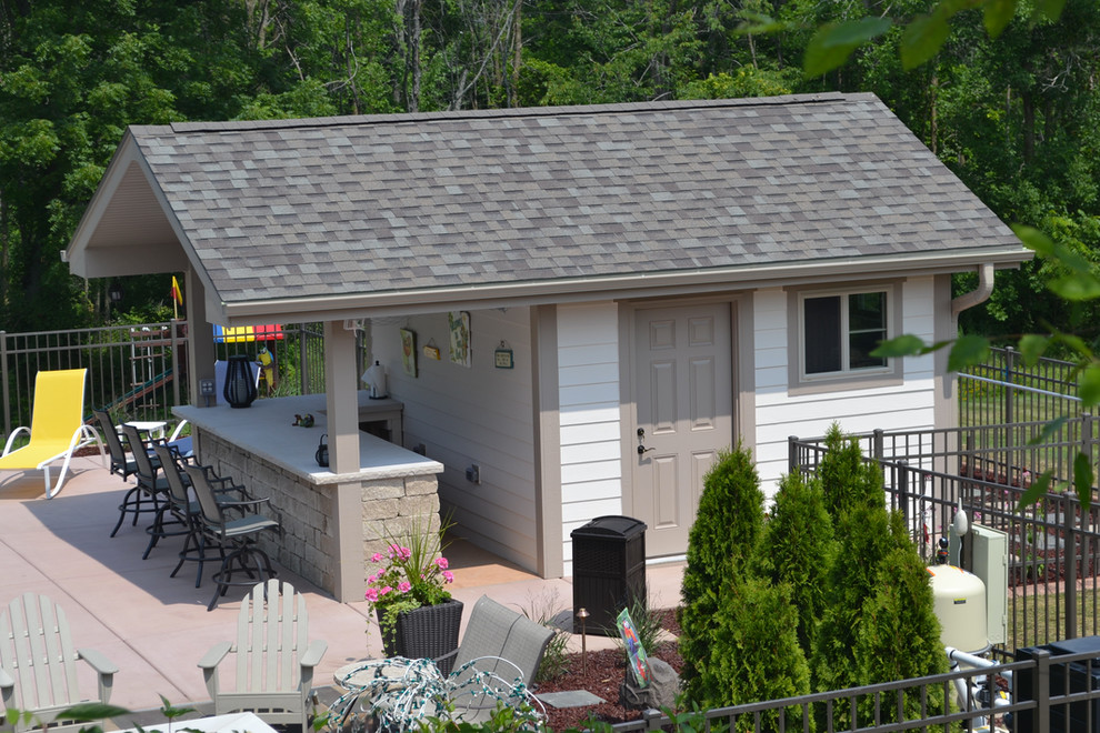 Immagine di un grande patio o portico tradizionale dietro casa con lastre di cemento e un tetto a sbalzo