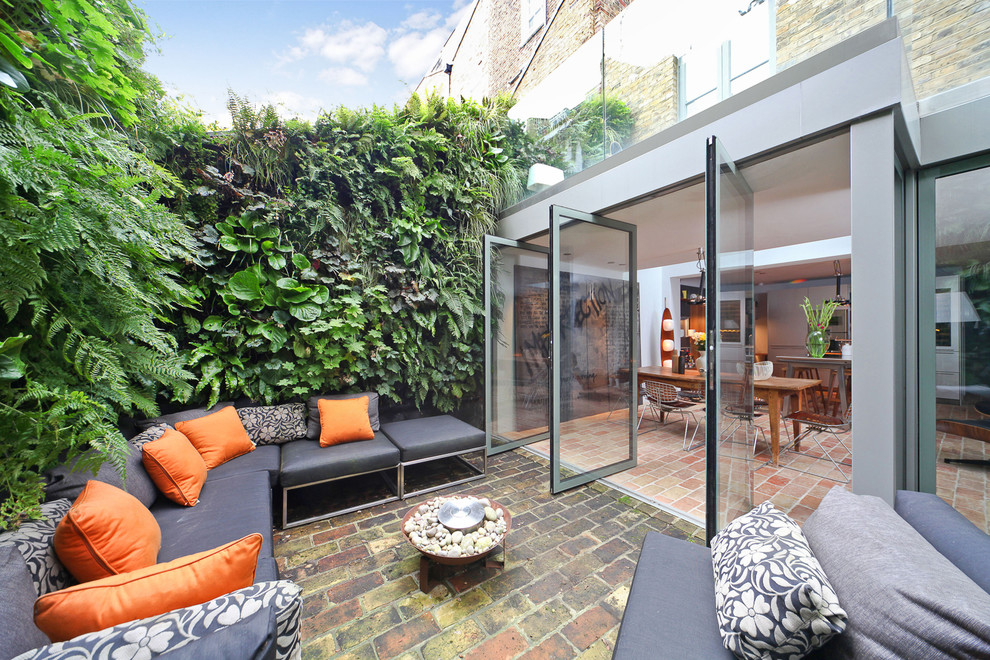 Patio - contemporary brick patio idea in London with no cover