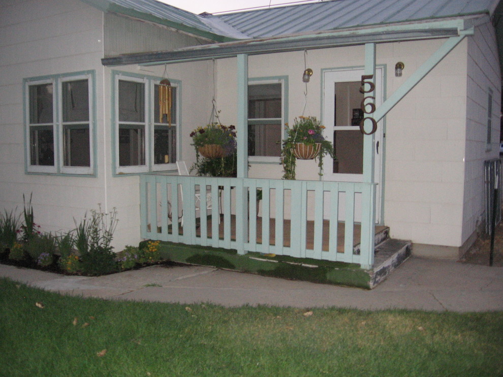 Immagine di un ampio patio o portico country davanti casa con lastre di cemento e una pergola