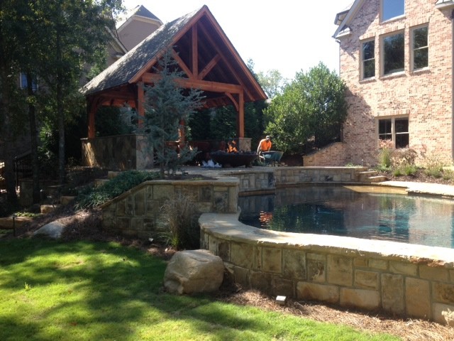 Huge mountain style backyard stone patio photo in Atlanta with a fire pit and a gazebo