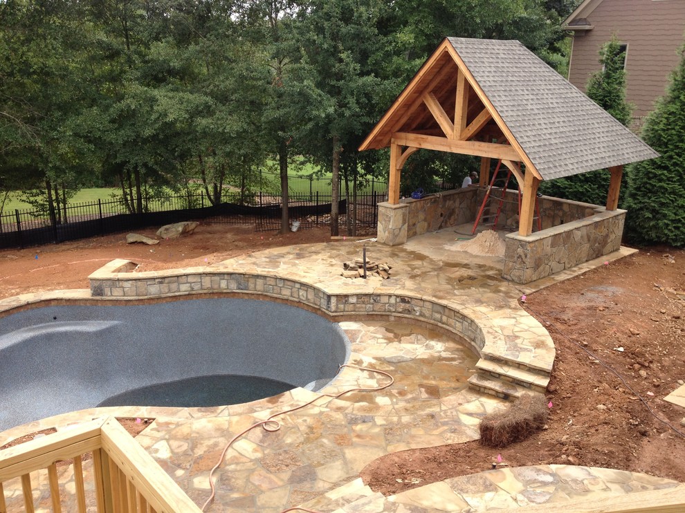 Inspiration for a huge rustic backyard stone patio remodel in Atlanta with a fire pit and a gazebo