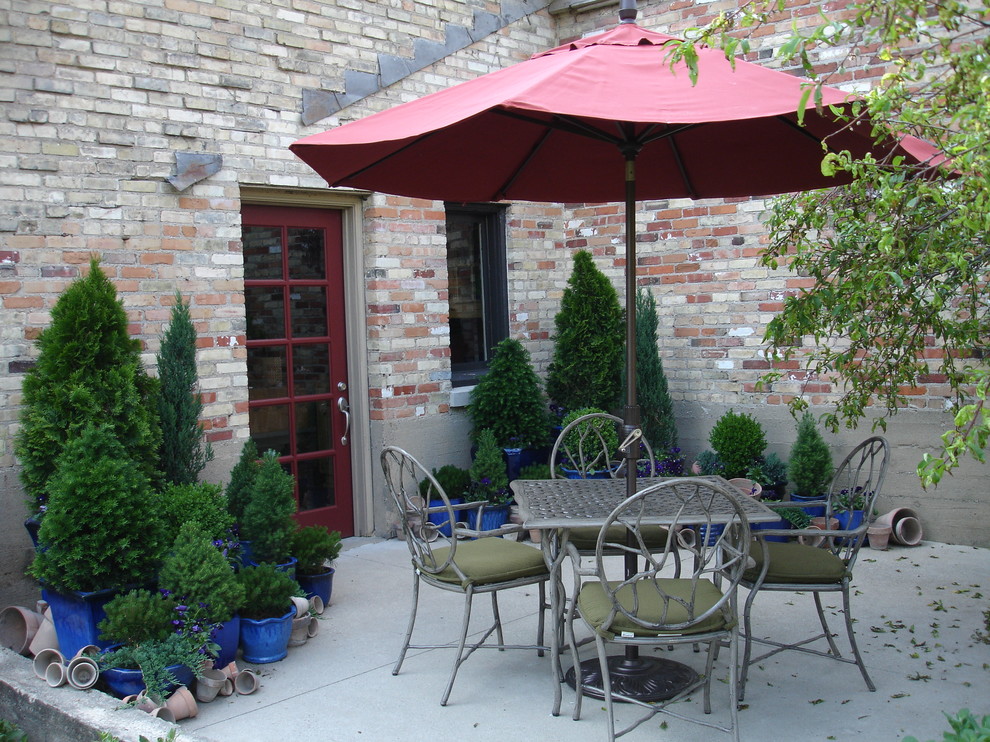 Inspiration for a mid-sized mediterranean courtyard concrete patio container garden remodel in Grand Rapids with no cover