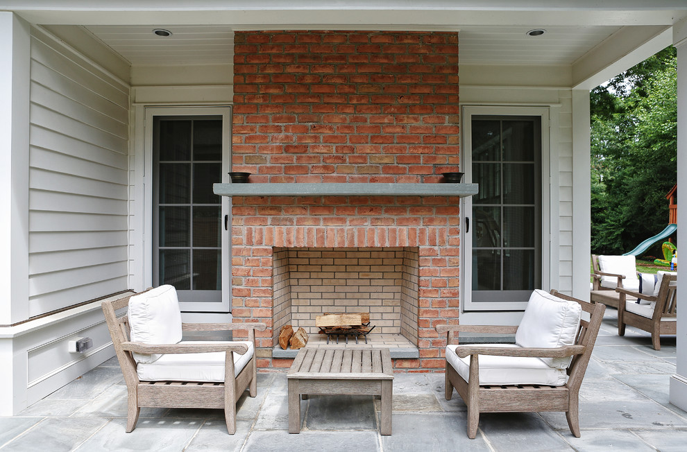 Cette photo montre une terrasse chic avec des pavés en pierre naturelle et un foyer extérieur.