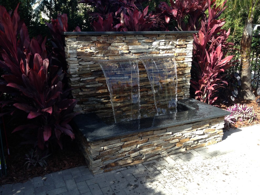 Inspiration for a small contemporary back patio in Tampa with a water feature, concrete paving and no cover.