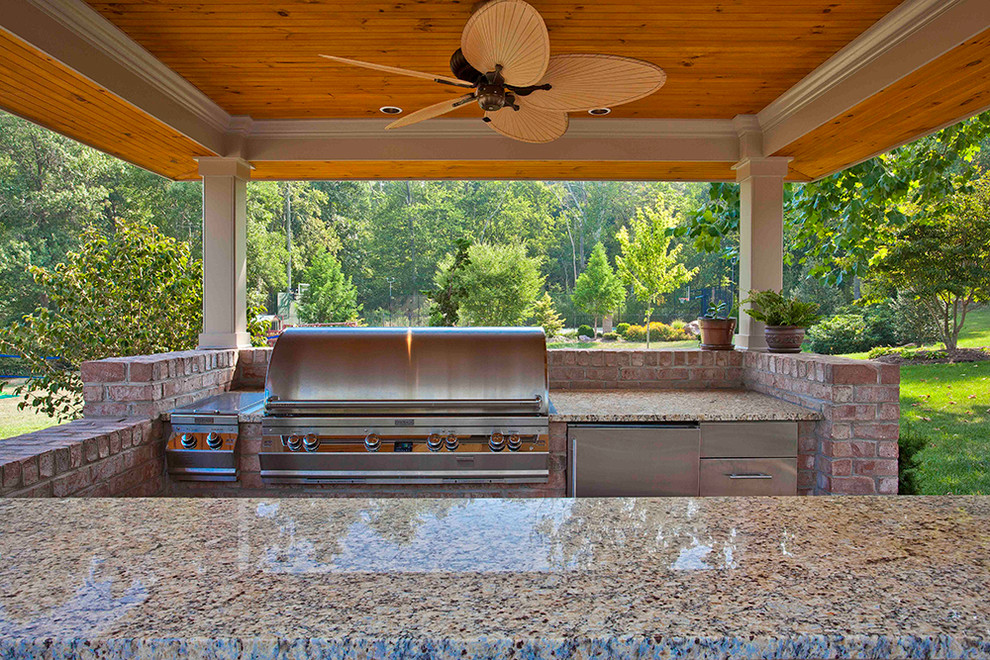 Cette image montre une grande terrasse arrière traditionnelle avec une cuisine d'été, une dalle de béton et un gazebo ou pavillon.