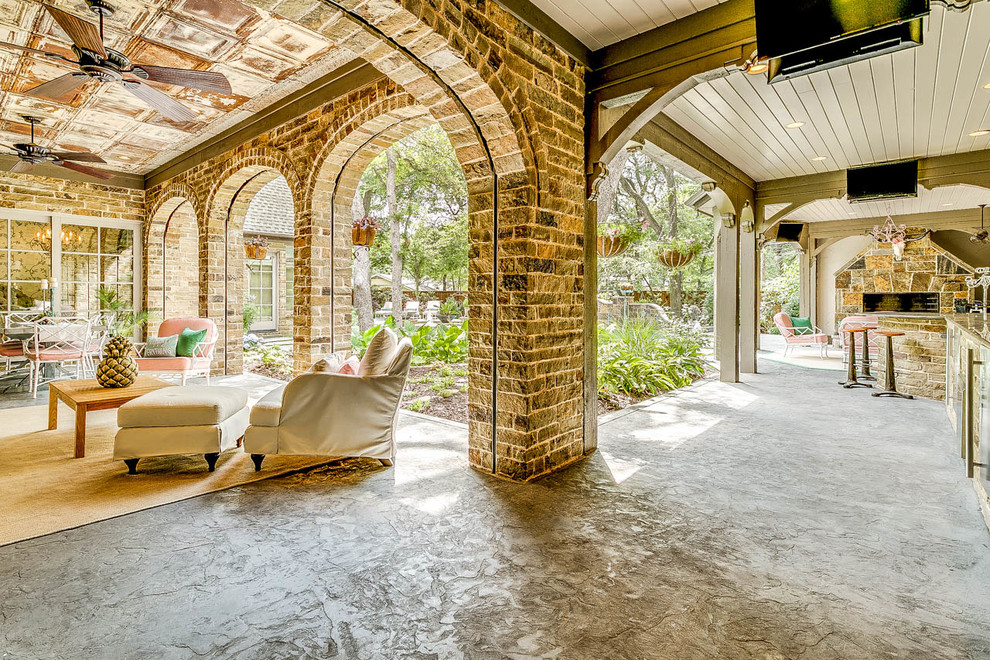 This is an example of an expansive vintage back patio in Dallas with an outdoor kitchen, natural stone paving and a roof extension.