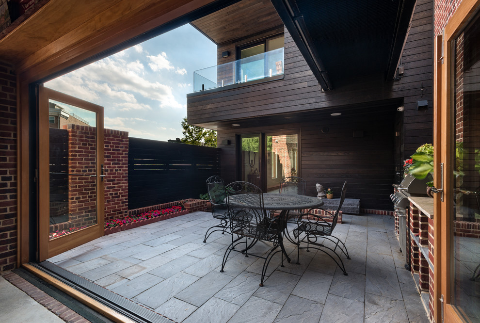 Imagen de patio minimalista de tamaño medio sin cubierta en patio con adoquines de piedra natural y cocina exterior