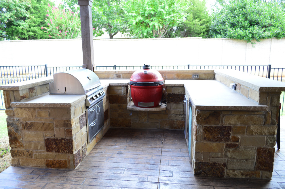 Überdachter Uriger Patio hinter dem Haus mit Outdoor-Küche und Stempelbeton in Dallas