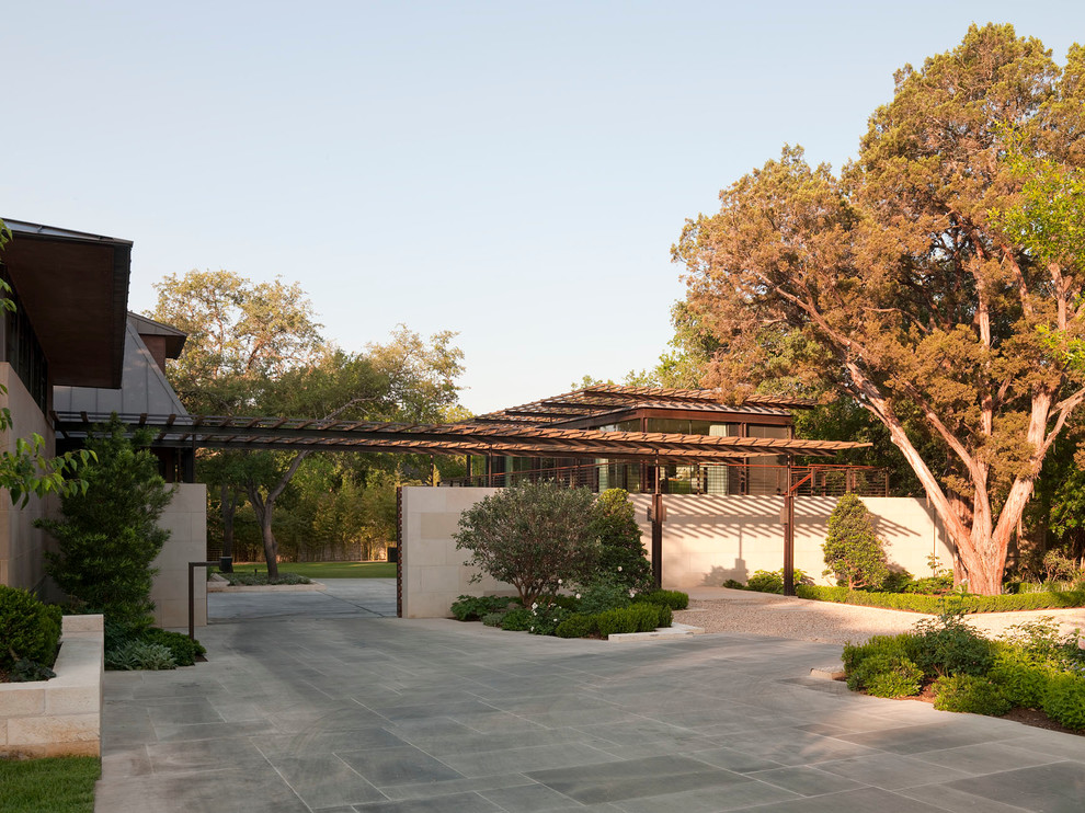 Imagen de patio moderno grande en patio trasero con adoquines de piedra natural y pérgola