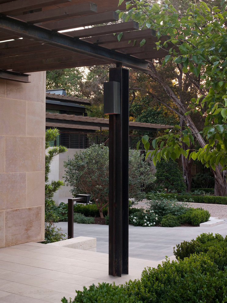 Foto di un patio o portico minimalista di medie dimensioni e dietro casa con una pergola e pavimentazioni in pietra naturale
