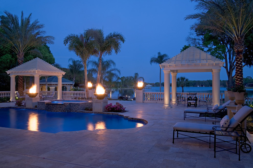 Immagine di un grande patio o portico tropicale dietro casa con un focolare, pavimentazioni in pietra naturale e una pergola