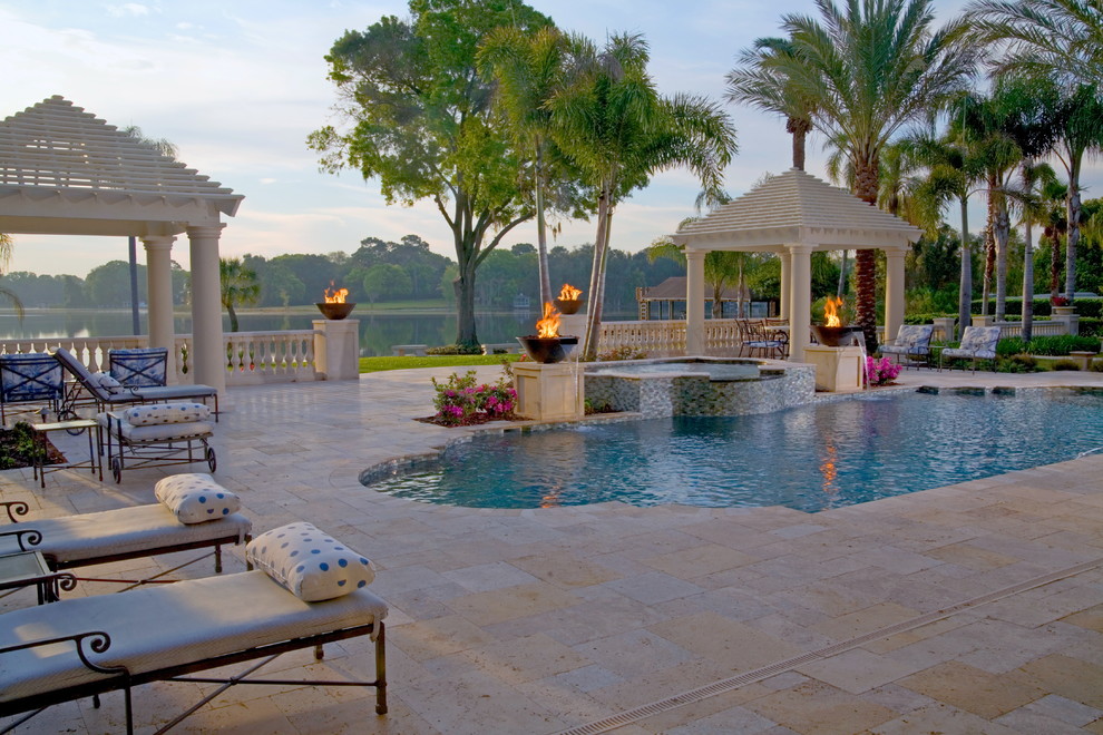 Large world-inspired back patio in Tampa with a fire feature, natural stone paving and a pergola.