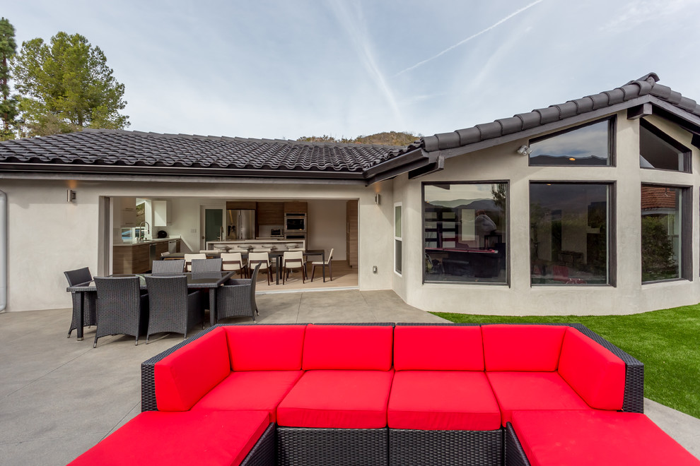 Unbedeckter Moderner Patio hinter dem Haus mit Outdoor-Küche und Betonplatten in Los Angeles