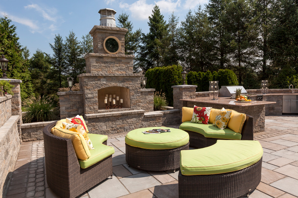 Design ideas for a large traditional back patio in Boston with a fireplace, natural stone paving and a gazebo.