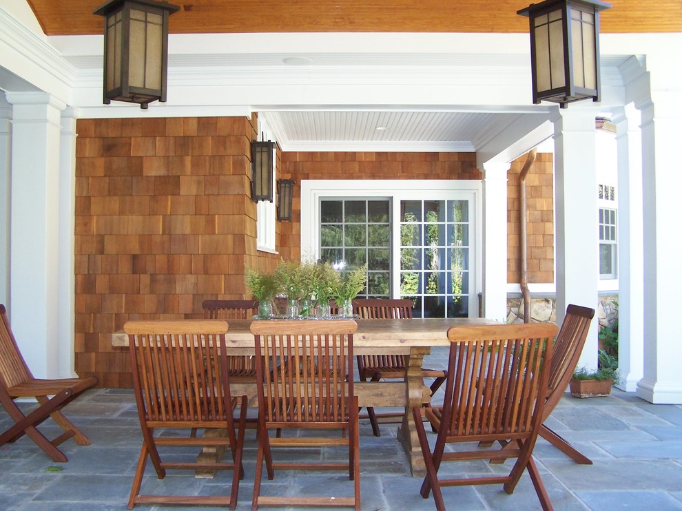 Immagine di un patio o portico country di medie dimensioni e dietro casa con piastrelle e un tetto a sbalzo