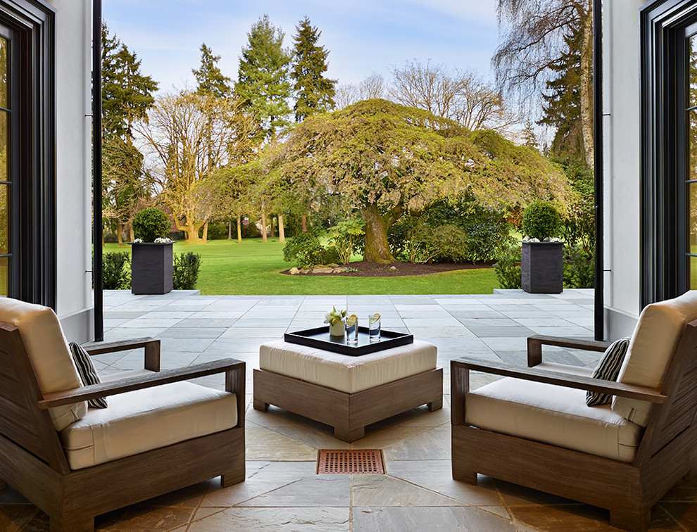 Imagen de patio clásico renovado grande en patio trasero y anexo de casas con adoquines de piedra natural