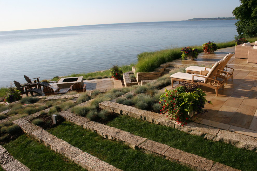 Exemple d'une terrasse tendance avec un foyer extérieur.