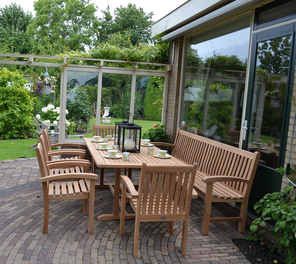 Immagine di un grande patio o portico nordico dietro casa con un giardino in vaso, pavimentazioni in mattoni e un parasole