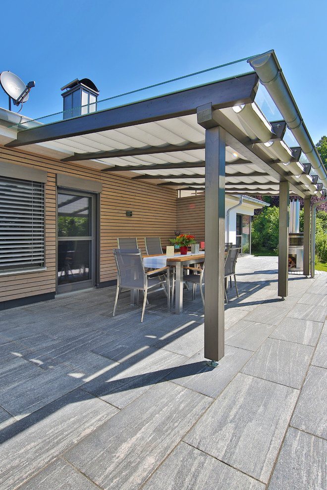 Immagine di un patio o portico minimal di medie dimensioni e nel cortile laterale con graniglia di granito e un parasole