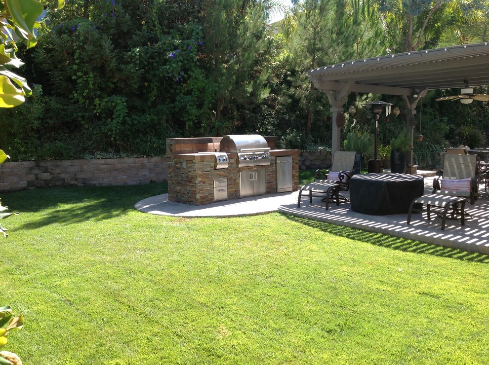 This is an example of a medium sized traditional back patio in Los Angeles with an outdoor kitchen, concrete slabs and a gazebo.