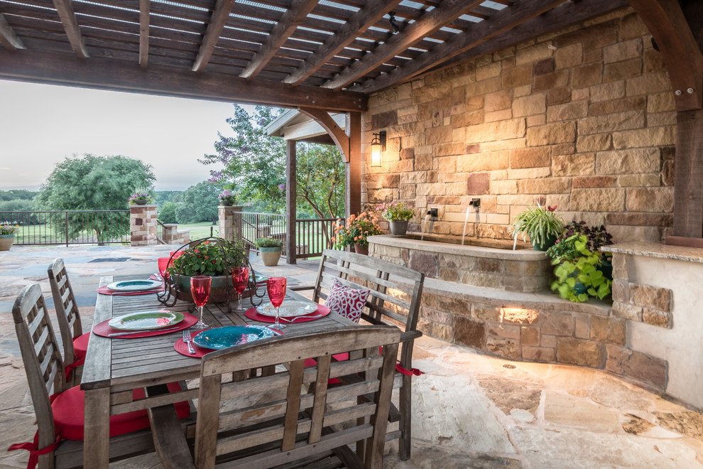 Modelo de patio actual extra grande en patio con cocina exterior, pérgola y adoquines de piedra natural
