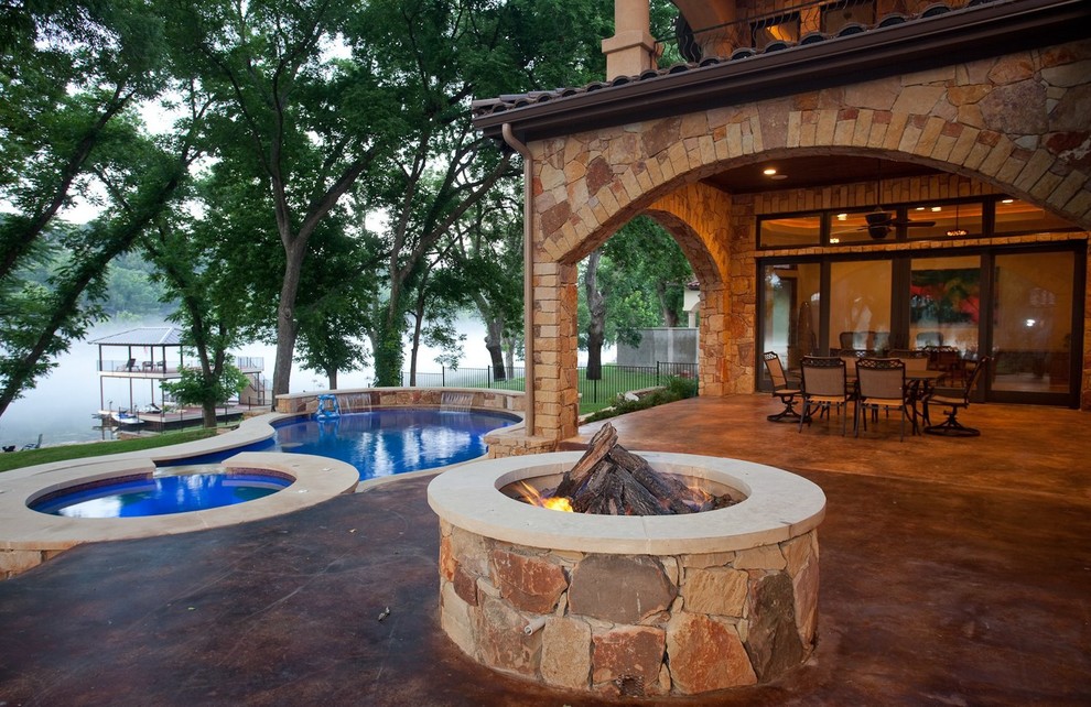 Inspiration for a mediterranean back patio in Austin with a fire feature, concrete slabs and a roof extension.