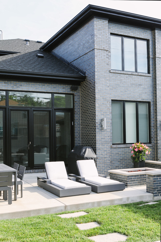 Idee per un patio o portico minimalista di medie dimensioni e dietro casa con un focolare, lastre di cemento e nessuna copertura