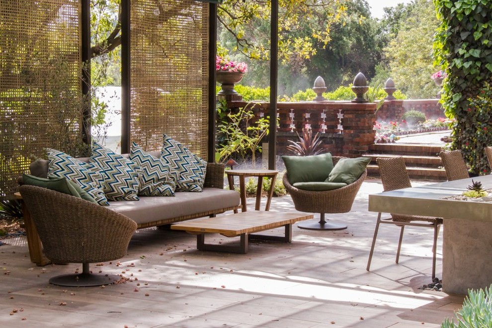 Immagine di un patio o portico design dietro casa con una pergola e piastrelle