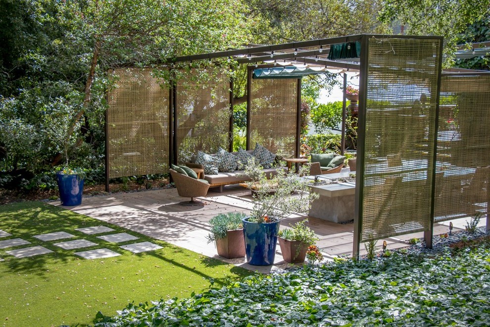 Inspiration pour une terrasse avec des plantes en pots arrière design avec des pavés en pierre naturelle et une pergola.