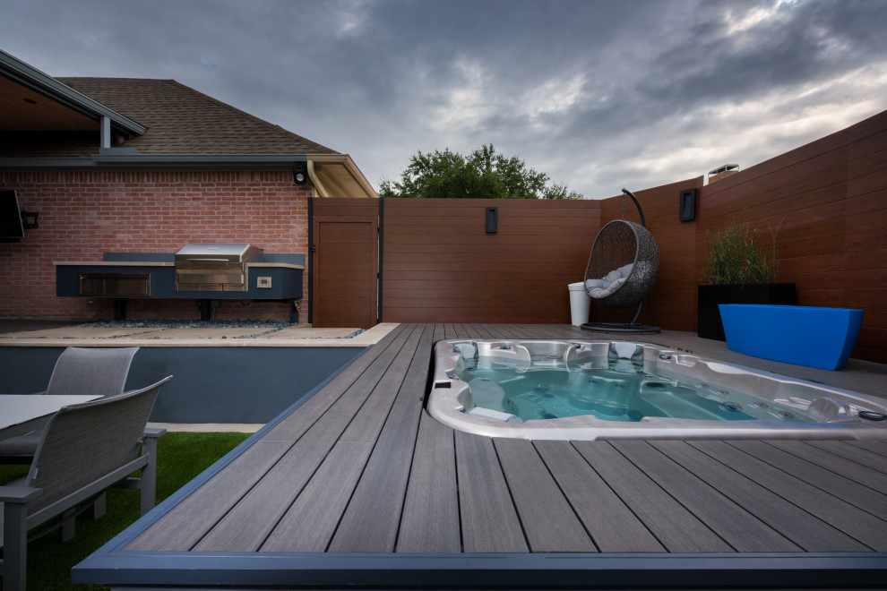 Inspiration for a small modern back patio in Dallas with a roof extension, an outdoor kitchen and concrete paving.